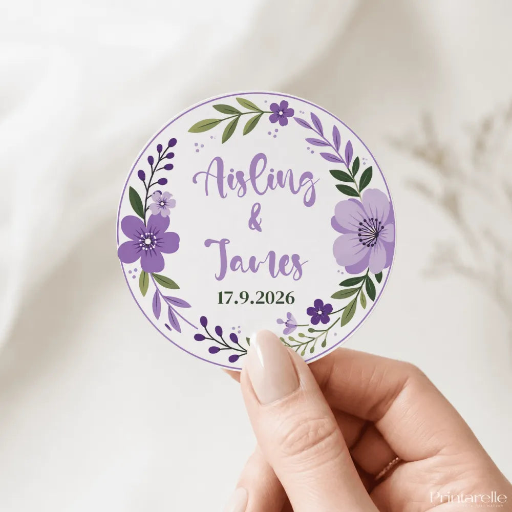 A circular purple and green floral wreath wedding favor sticker with aisling and james real foil colors date 17.9.2026