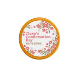 A 40mm milk chocolate confirmation chocolate coin with gold edge and pink floral design for clara’s confirmation day