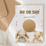 Gender reveal card with two bunnies and a scratch-off panel on a white background