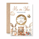 Gender reveal card with cartoon animals and text 'He or She Scratch to See We are having a Baby Boy'.