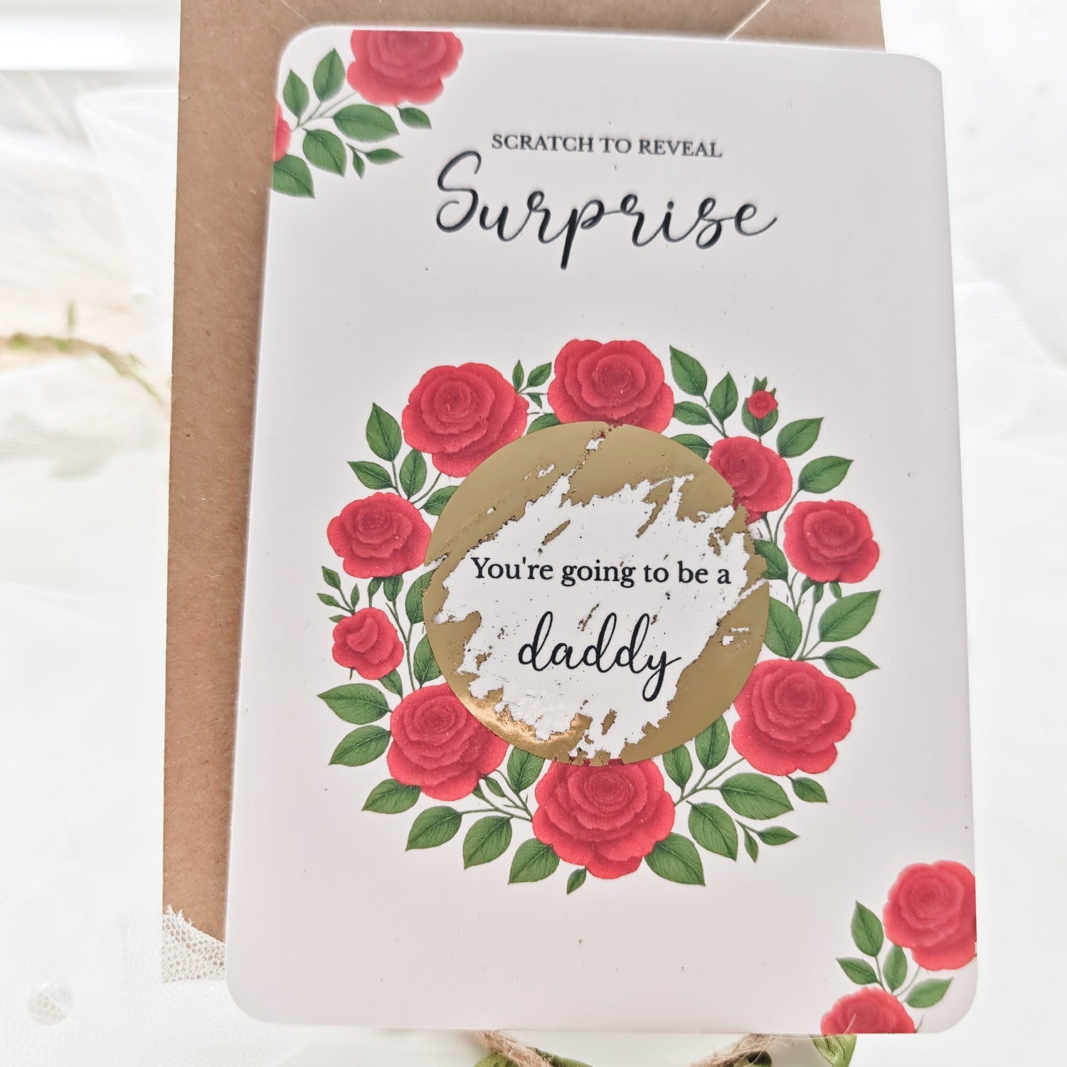 Flat lay of red rose scratch reveal card with gold sticker