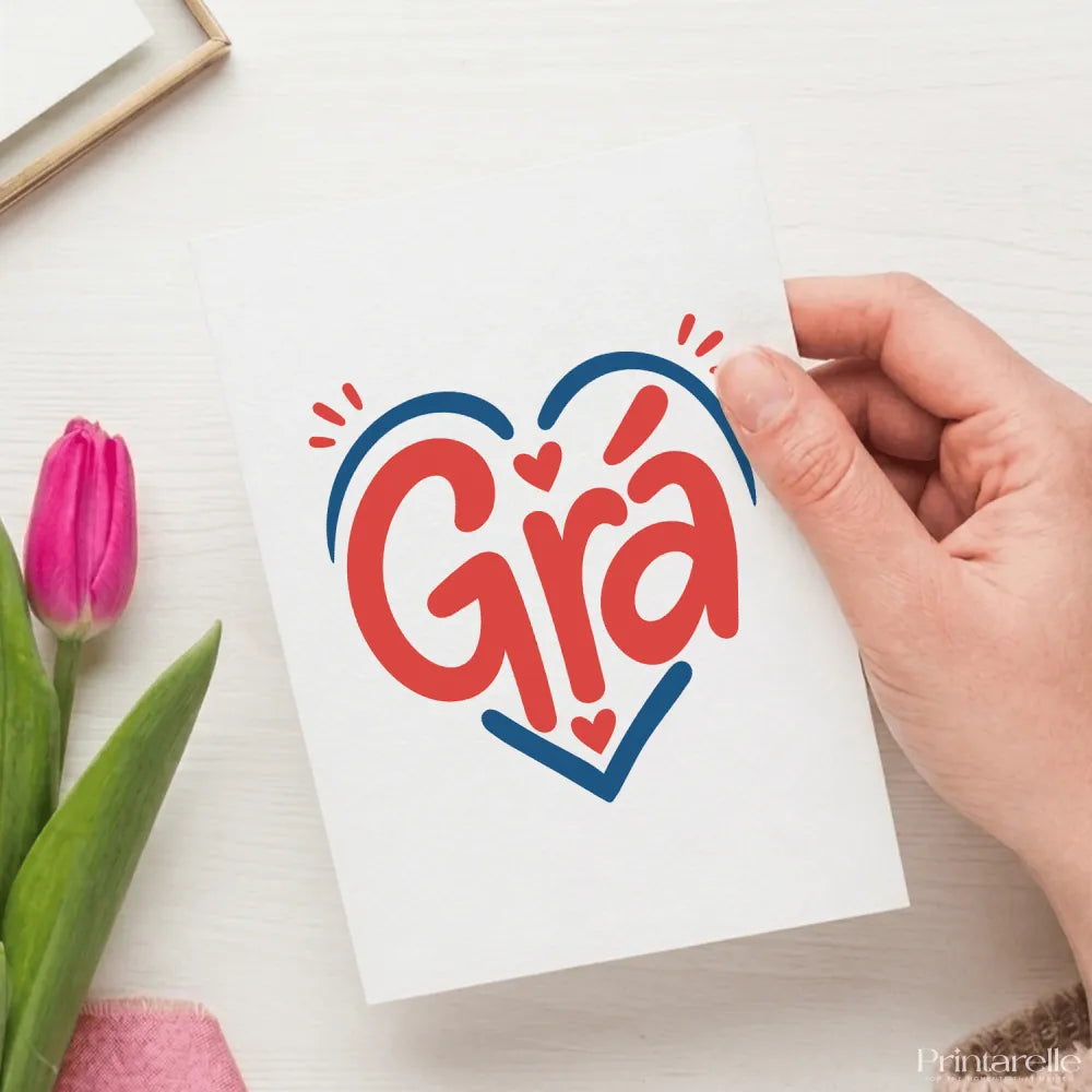 A white irish love card with the word grà in bold red script inside a blue heart with small hearts and rays