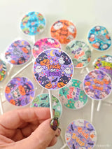 A purple circular lollipop with trick or treat text wrapped in clear plastic from a halloween favour bundle