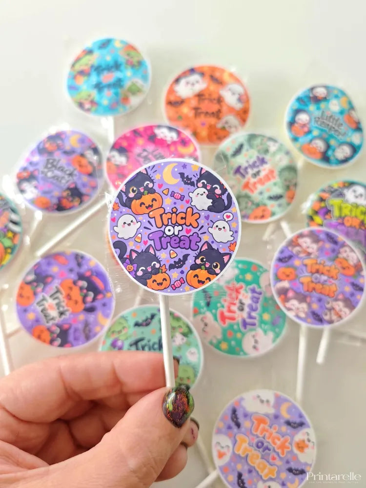 A purple circular lollipop with trick or treat text wrapped in clear plastic from a halloween favour bundle