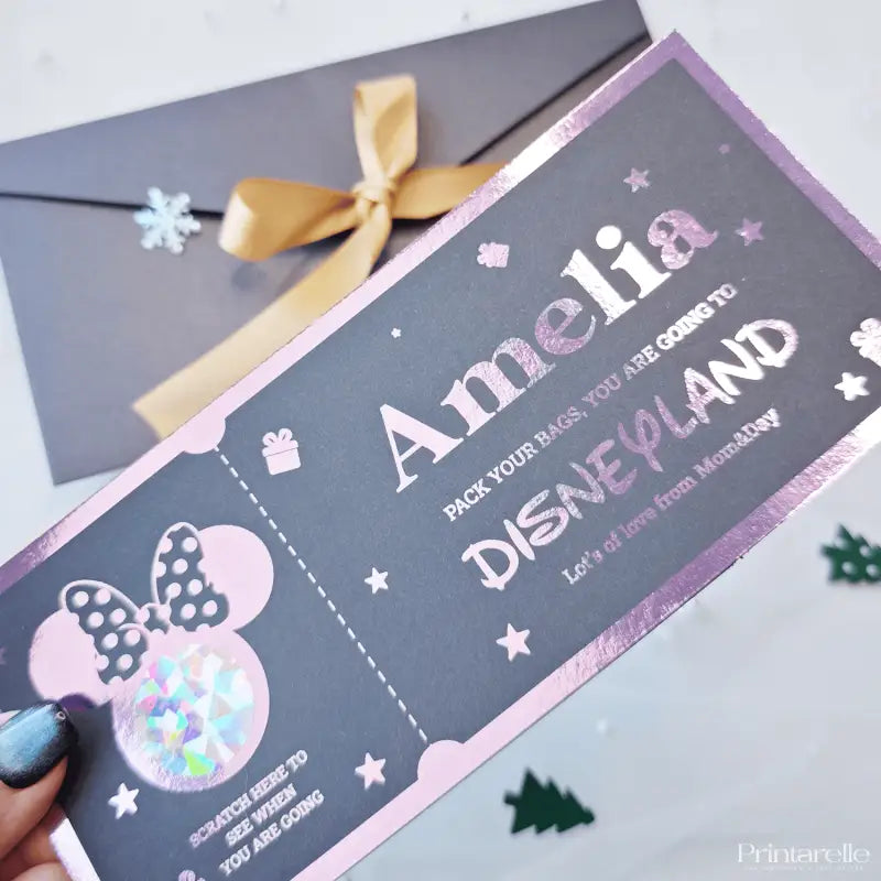 Personalized Disneyland ticket-style card with a bow on a white surface