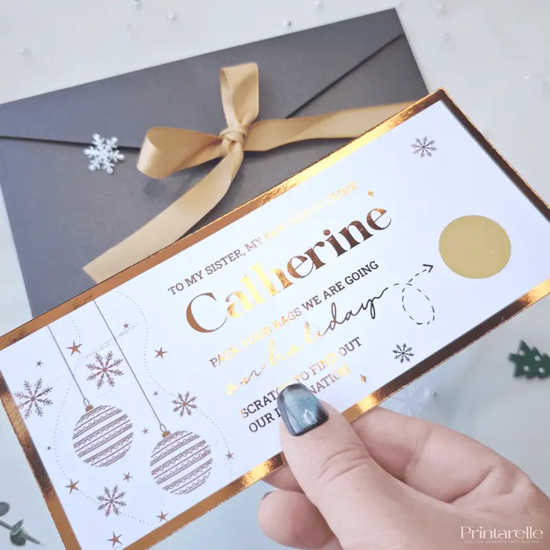 Hand holding a Christmas-themed gift card with decorative elements on a white background
