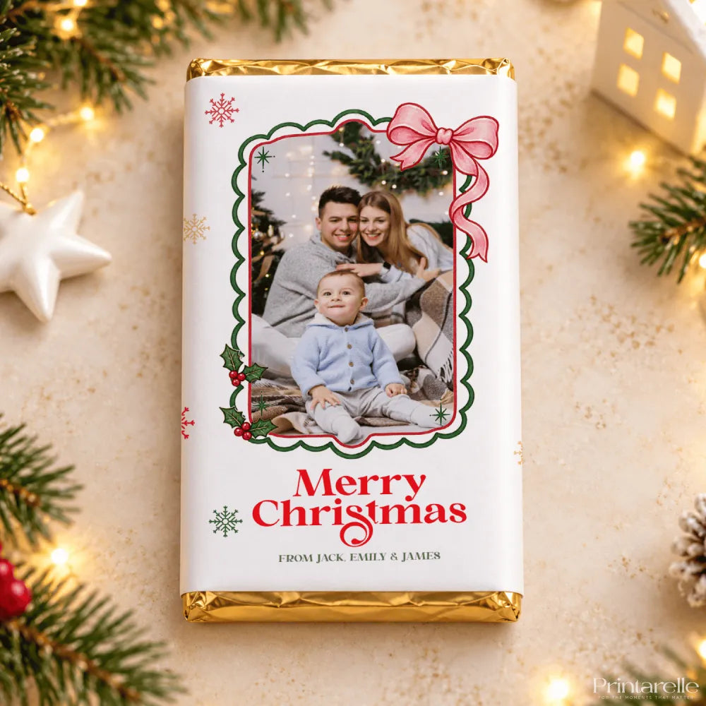 A white chocolate bar with gold foil edges featuring a christmas photo framed by green holly and a pink bow holly photo frame gift wrap