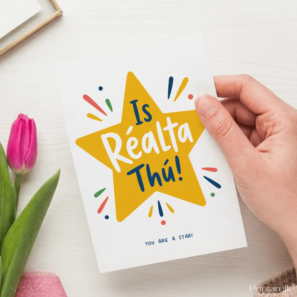 A white greeting card with a bold yellow star and playful lettering saying is réalta thú blank inside