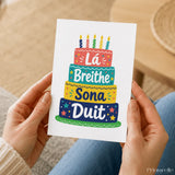 A colorful lá breithe sona duit birthday card with multi-tiered cake and rainbow candles for breithe sona wishes