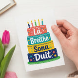 Lá breithe sona duit birthday card with colorful illustrated four-tiered rainbow cake and candles for breithe sona wishes