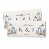 Cream-colored personalised 40g chocolate bar with blue lanterns and floral designs featuring two initials in foil wrap