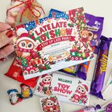 A festive late late toy stay up late pass with a cartoon owl in santa hat surrounded by christmas treats and decorations