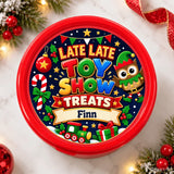 Red plastic container with festive late late toy show treats label featuring elf candy cane and holiday decorations