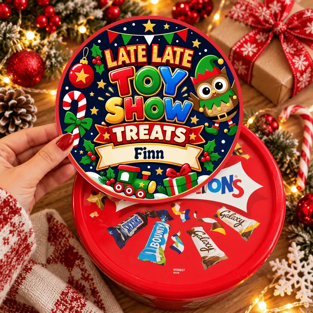A festive red and blue circular tin with a cartoon elf candy canes and presents labeled late late toy show treats tub sticker