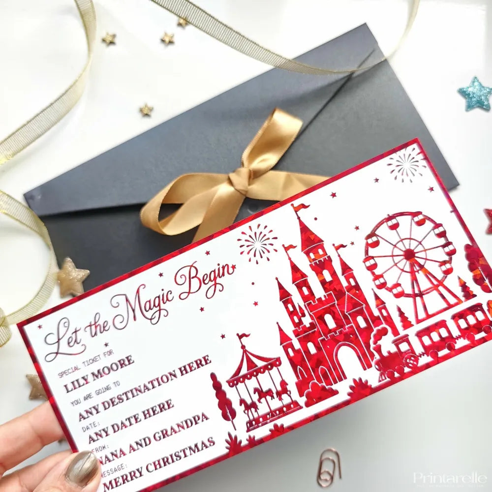 Red laser cut paper reveal card with festive castles ferris wheel and carousel design to let the magic begin