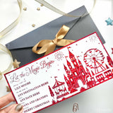 Red laser cut paper reveal card with festive castles ferris wheel and carousel design to let the magic begin