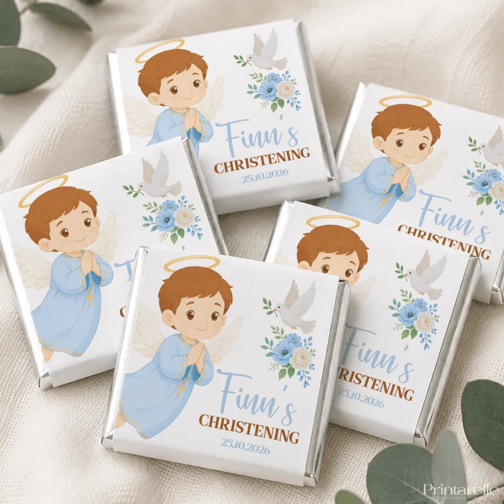 White chocolate christening mini neapolitans with a cartoon angel boy in blue robe and doves on floral wrappers