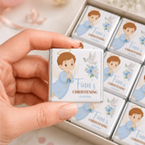 A hand holds a silver wrapped little angel boy christening mini neapolitans chocolate bar with a cartoon angel design