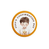 A circular gold-edged confirmation chocolate coin with a boy holding a chalice and finn’s confirmation day text