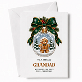 A festive grandad christmas card featuring a gingerbread grandad with round glasses and bow tie in a snow globe ornament
