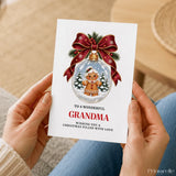 A festive white grandma christmas card featuring a gingerbread grandma inside a clear glass bauble with red ribbon and greenery