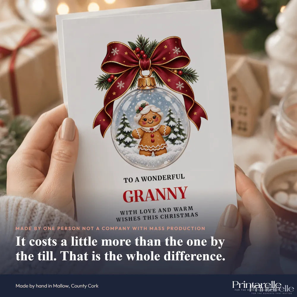 A festive white granny christmas card featuring a gingerbread granny inside a glass bauble with red ribbon and pine sprigs