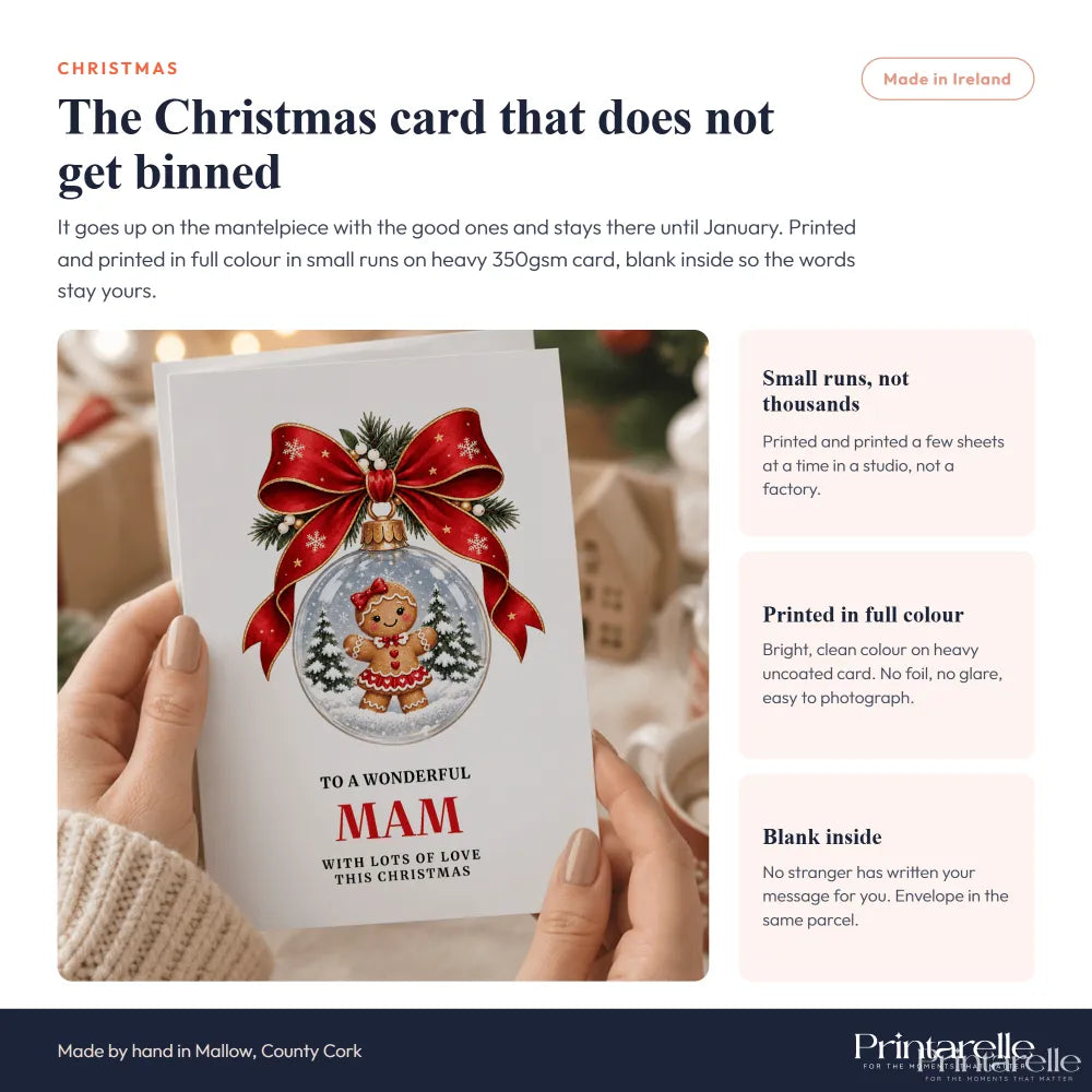 A festive white mam christmas card with a gingerbread girl inside a snow globe and a red bow decoration