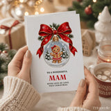 A festive white mam christmas card featuring a gingerbread girl in a red dress inside a snow globe with a red bow
