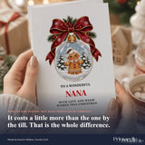 A nana christmas card featuring a little gingerbread bauble with a red ribbon and gold bell in a snowy scene
