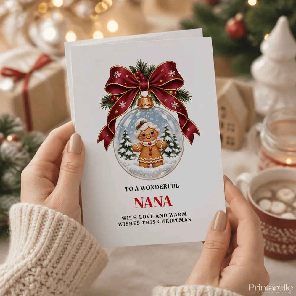 A festive white nana christmas card featuring a gingerbread woman inside a glass bauble with a heart brooch charm