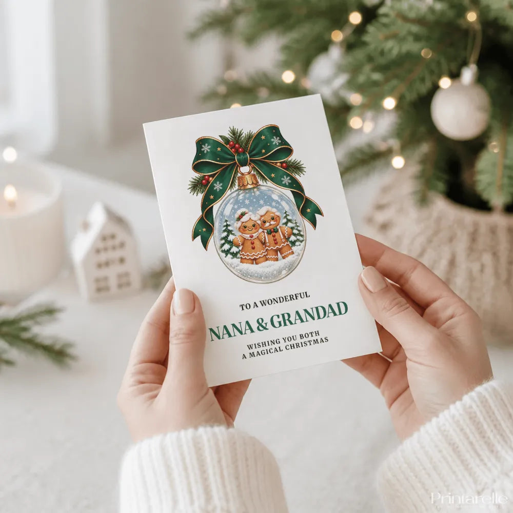 A white personalised nana and grandad christmas card with gingerbread men in a glass bauble and green ribbon bow