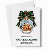 A festive white personalised nana and grandad christmas card with a glass bauble and gingerbread figures design