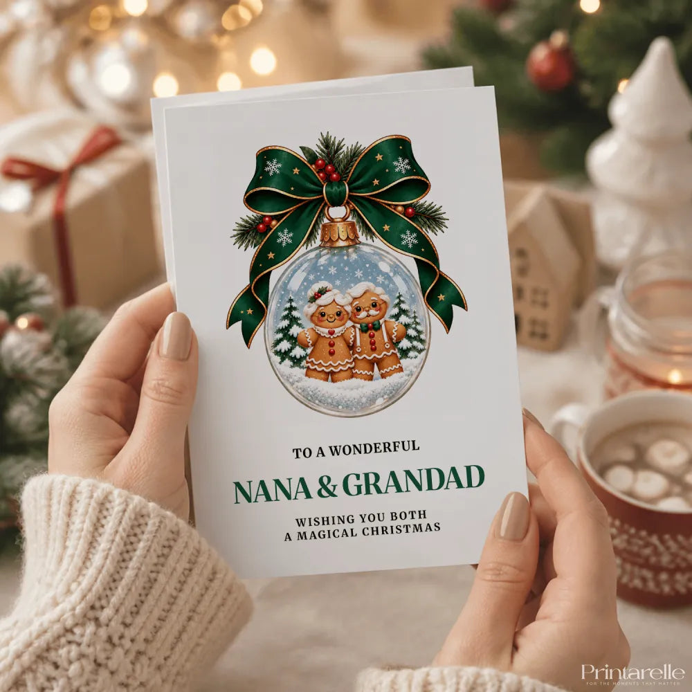 A white personalised nana and grandad christmas card with gingerbread men in a glass bauble and green ribbon bow