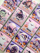 Pink and purple mini neapolitan chocolates featuring cute halloween ghosts witches and pumpkins in little monsters boxes