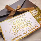 Invitation card with gold text and a brown ribbon on a gray surface