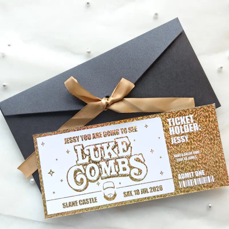 Concert ticket with gold and white design on a black envelope with a gold ribbon.