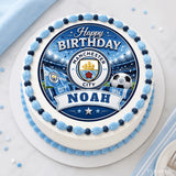 A round white cake with blue scalloped frosting and a manchester city edible icing sheet cake topper with noah banner