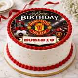 A white frosted birthday cake with red borders and gold sprinkles topped with a manchester united icing sheet cake topper