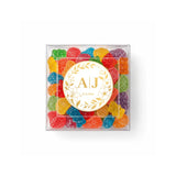 Clear box filled with colorful gummy bears with monogram wreath foil sticker for wedding date on top