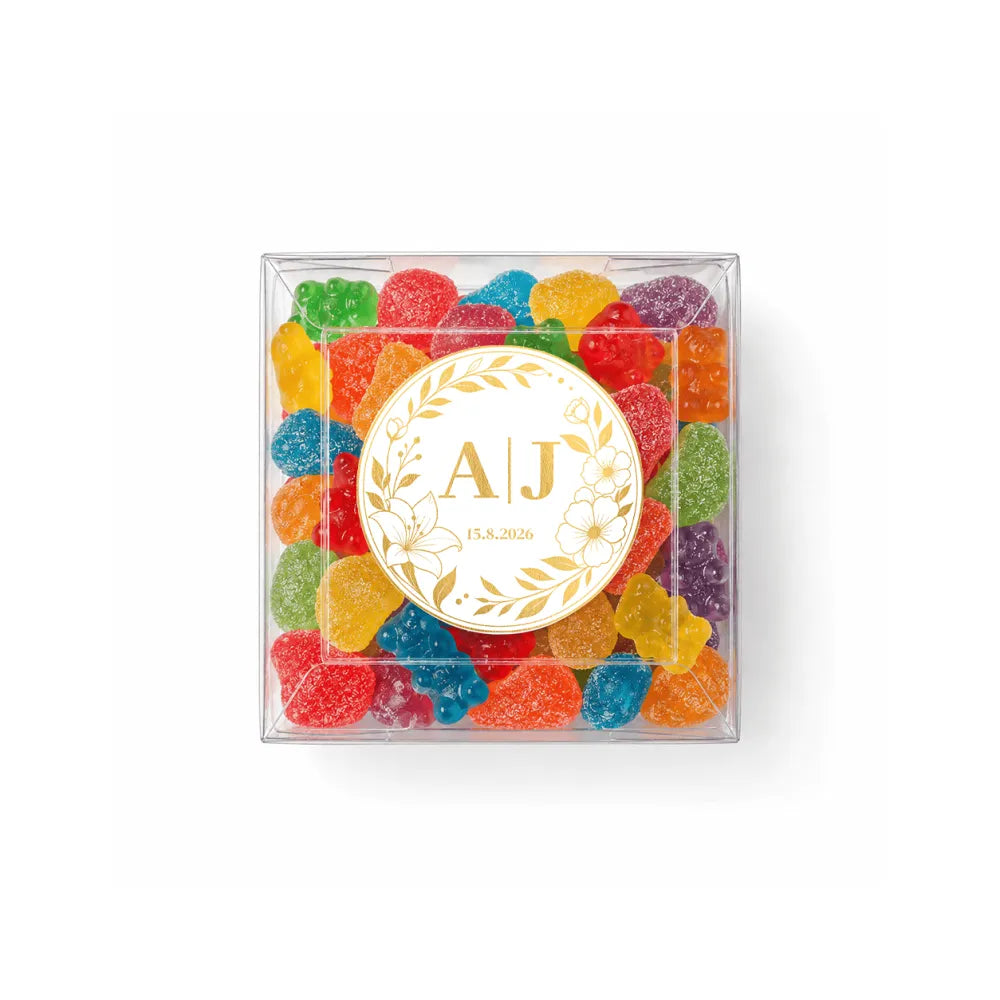 Clear box filled with colorful gummy bears with monogram wreath foil sticker for wedding date on top