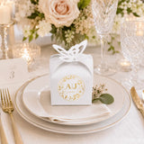 White paper wedding favour box with gold foil monogram wreath and butterfly topper perfect for wedding favours