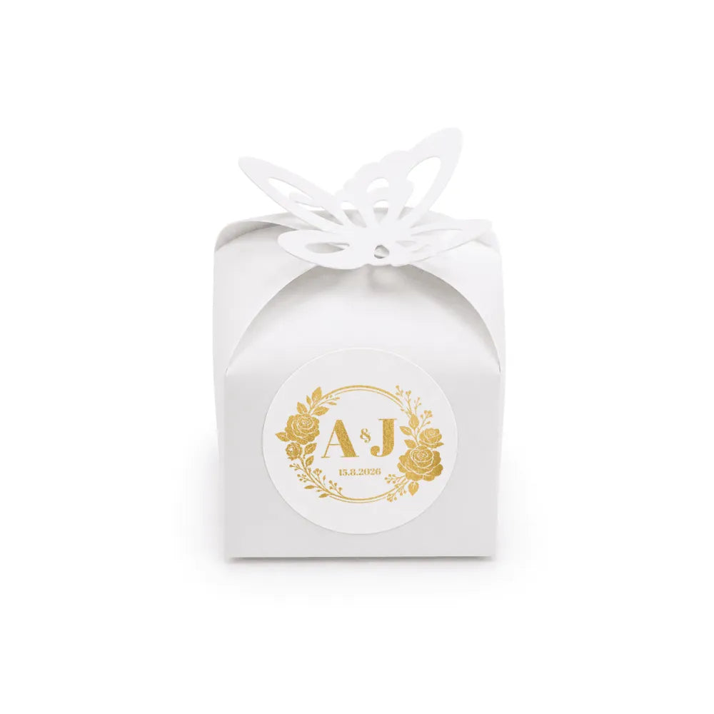 White paper favour box with gold foil monogram wreath stamp and butterfly cutout for wedding favours