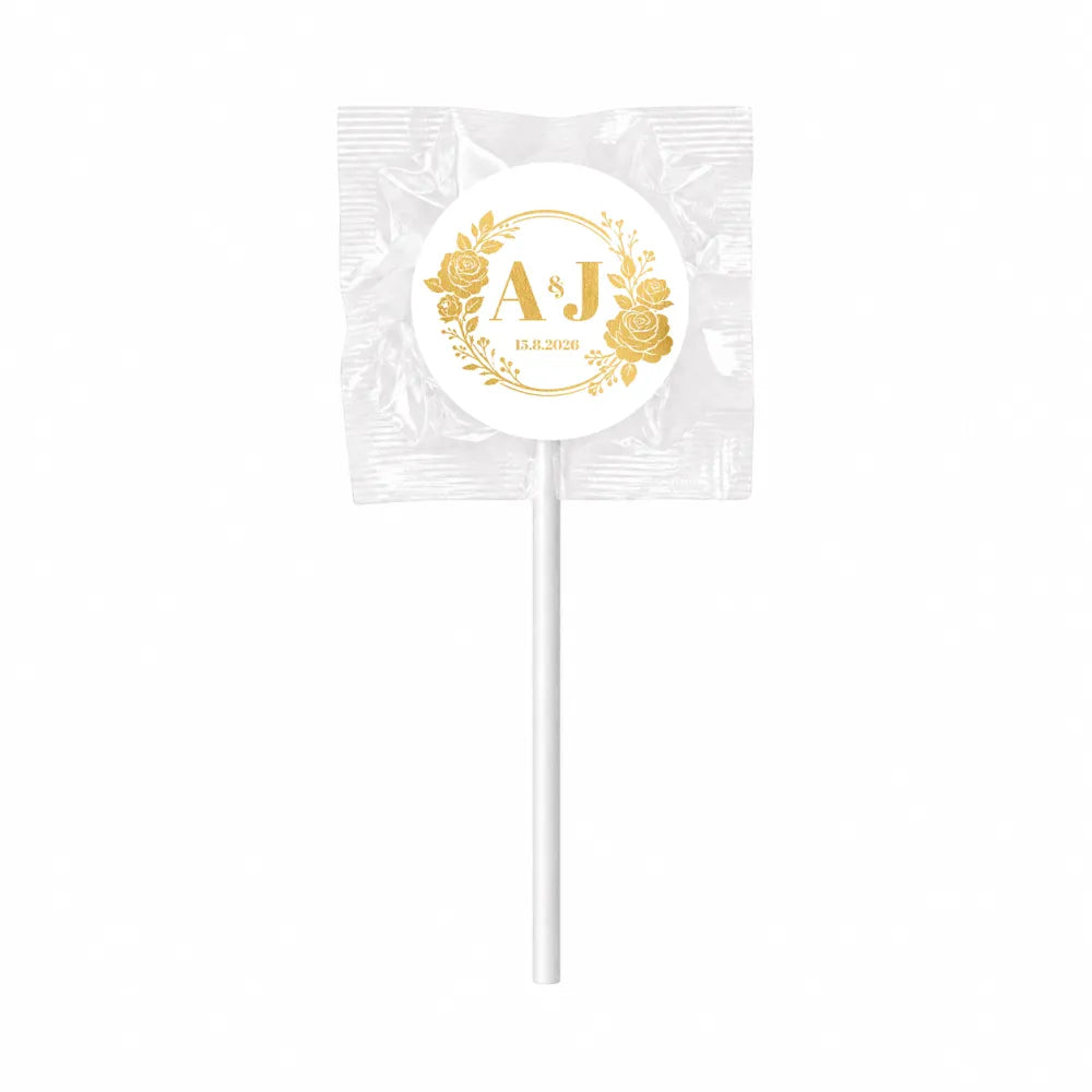 A white monogram wreath foil sticker lollipop wrapped fruit wedding favour with gold sticker and floral design