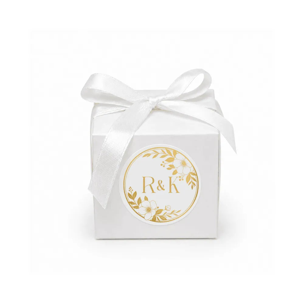 White cube favour box with monogram wreath foil sticker and satin ribbon for wedding gifts