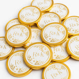 Gold-foiled 40mm milk chocolate coins with white centers and r&k monogram in floral wreath perfect for wedding favours