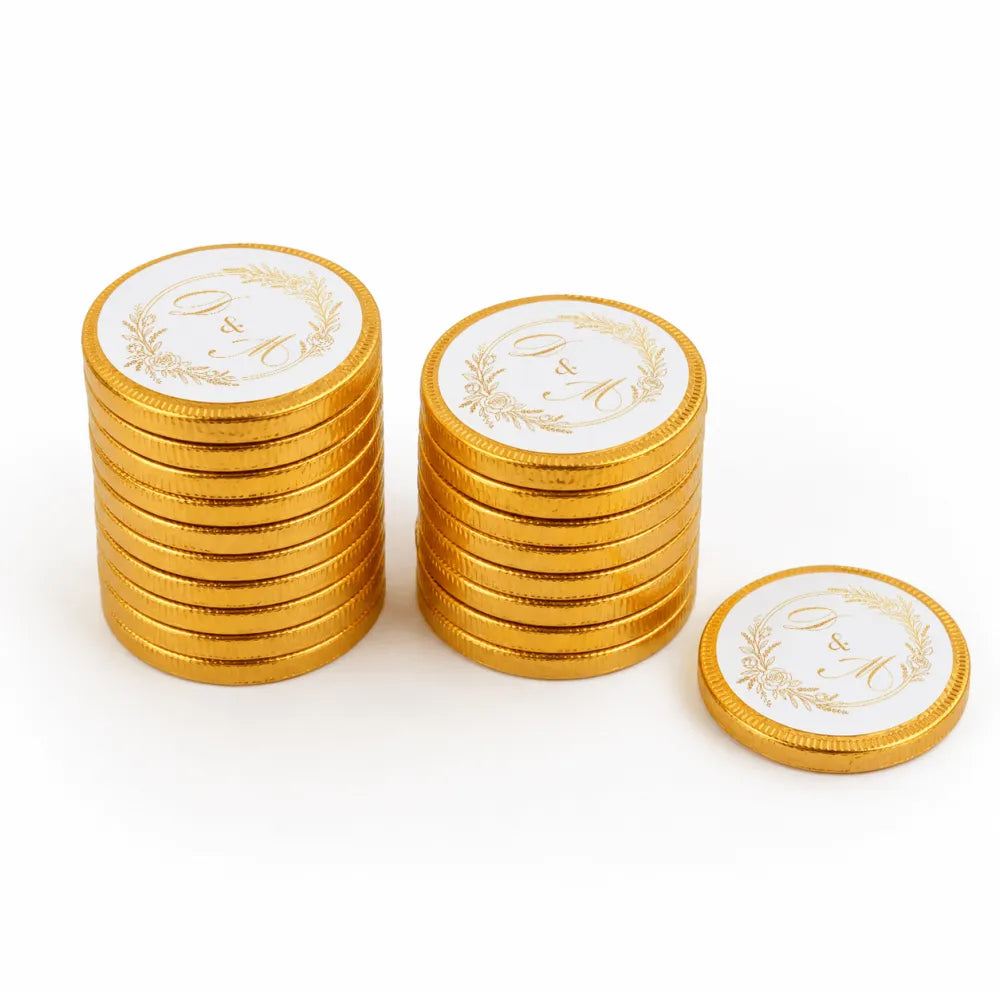 Golden 40mm milk chocolate coins with white centers featuring gold embossed g and m monograms for wedding favours