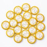 Golden 40mm milk chocolate coins with white centers and r and k monogram surrounded by floral wreaths for wedding favours