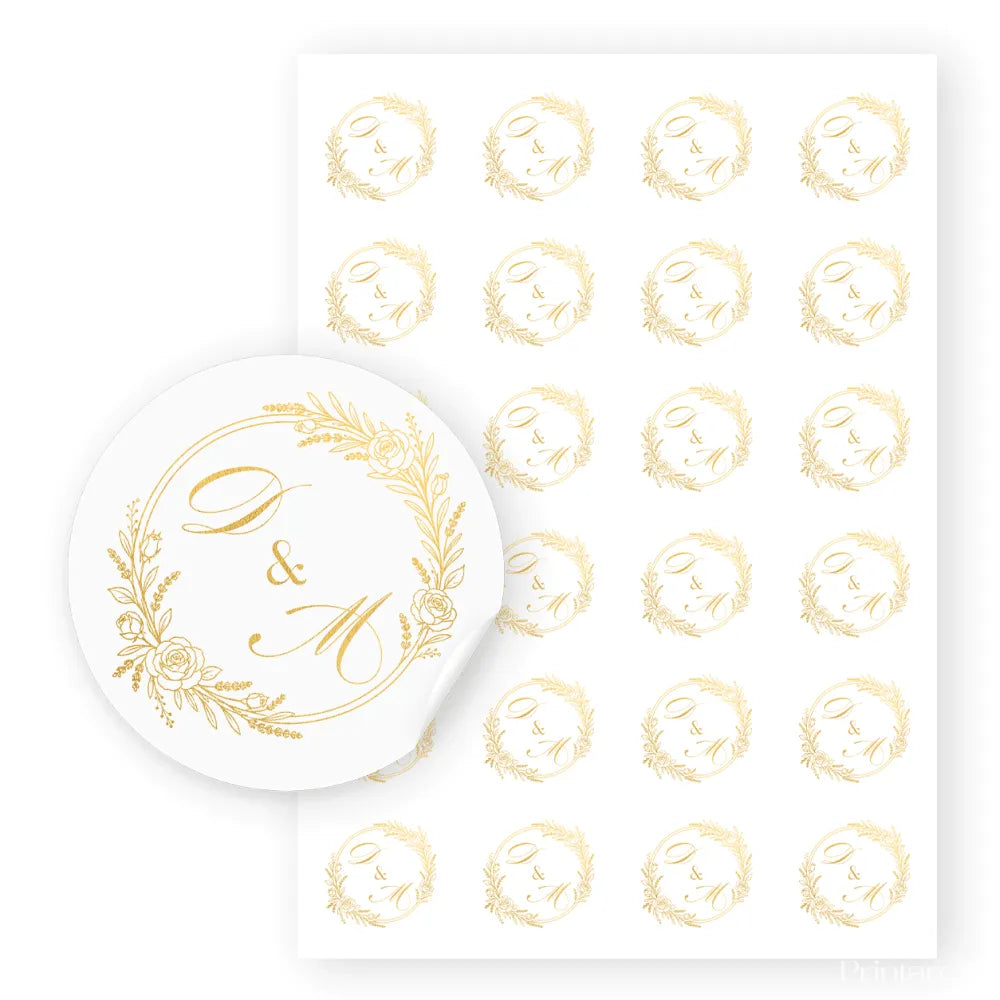 White circular wedding sticker with gold real foil monogram d and m in an ornate monogram wreath design