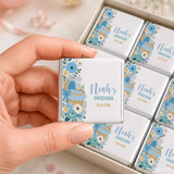 A white chocolate mini neapolitan with blue floral design and baby carriage for noah’s christening moses basket style