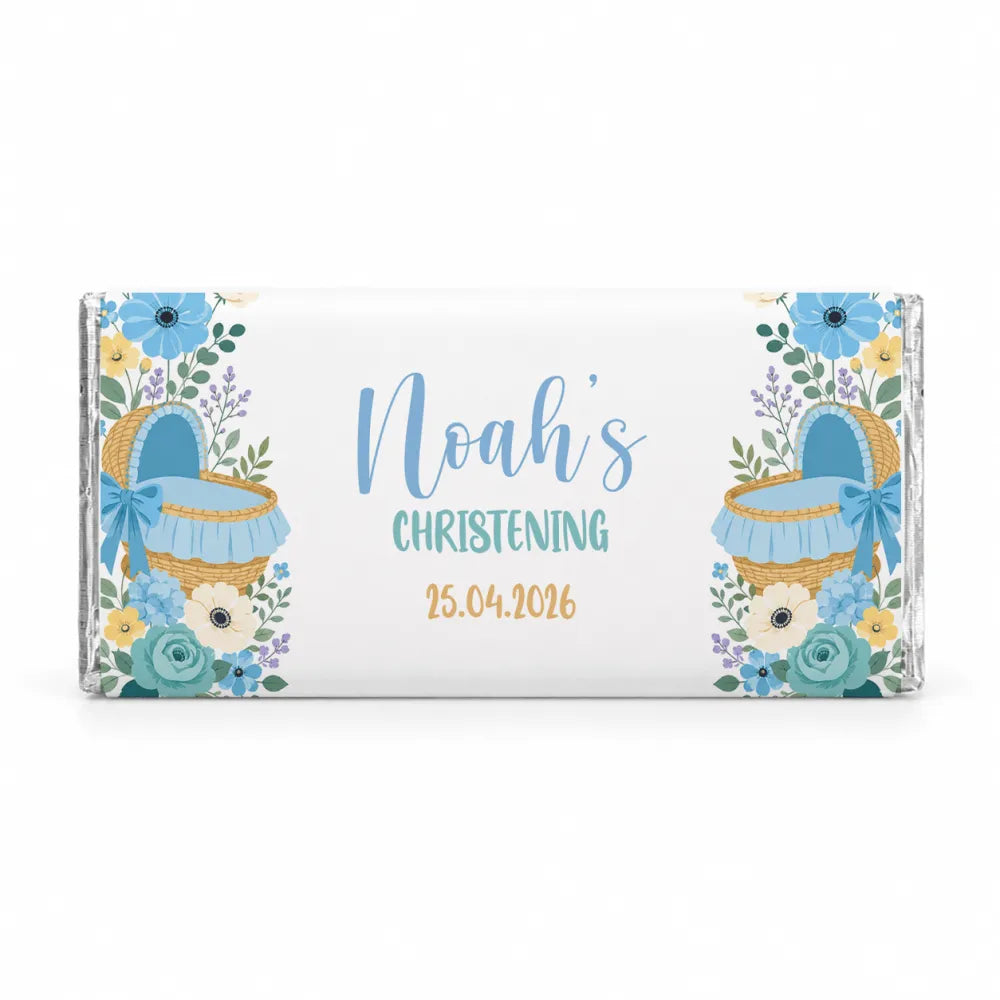 A personalized white chocolate bar with a delicate floral design and blue moses basket for noahs christening